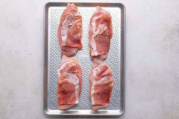 Grinder Sandwich, meat slices topped on the toast in eight pieces on a tray 