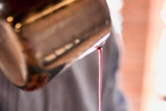 a person pouring syrup on a plate of food