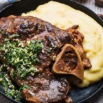 Deliciously braised veal shanks plated with fresh herbs and vegetables