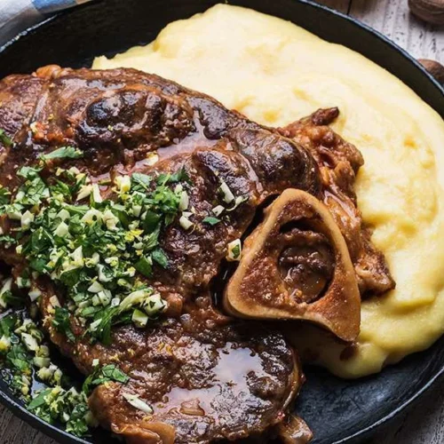 Deliciously braised veal shanks plated with fresh herbs and vegetables