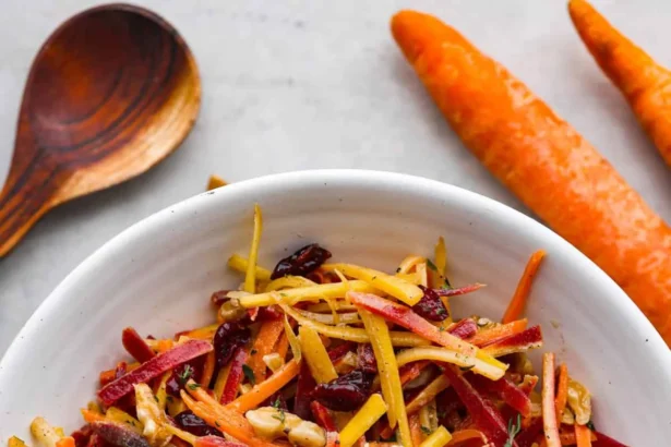 Fresh and colorful carrot salad served in a bowl, garnished with herbs.