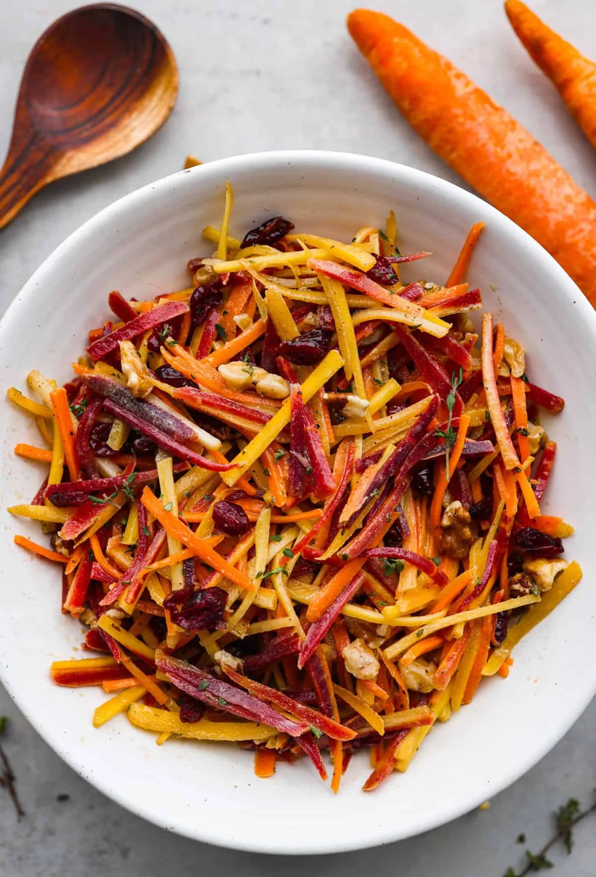 Fresh and colorful carrot salad served in a bowl, garnished with herbs.