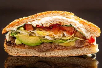A delicious cemita sandwich featuring meat, avocado, and fresh ingredients.