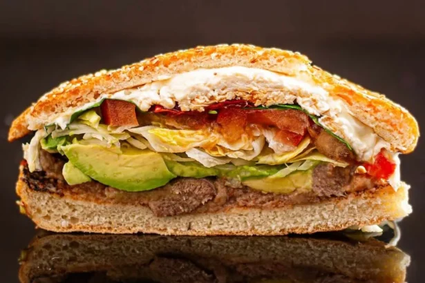 A delicious cemita sandwich featuring meat, avocado, and fresh ingredients.