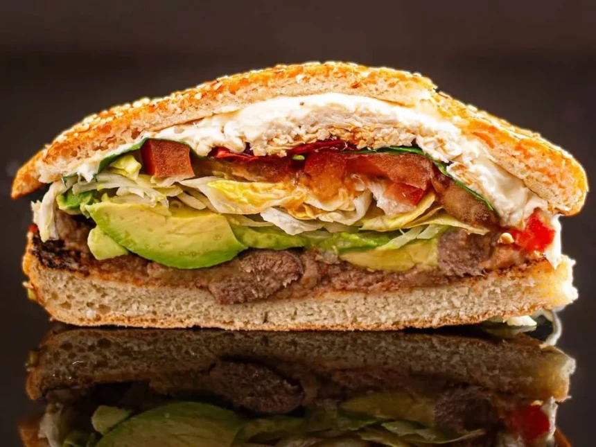 A delicious cemita sandwich featuring meat, avocado, and fresh ingredients.