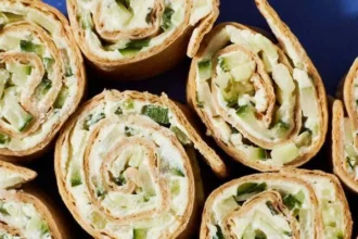 Cucumber Boursin Wrap on a plate with fresh herbs