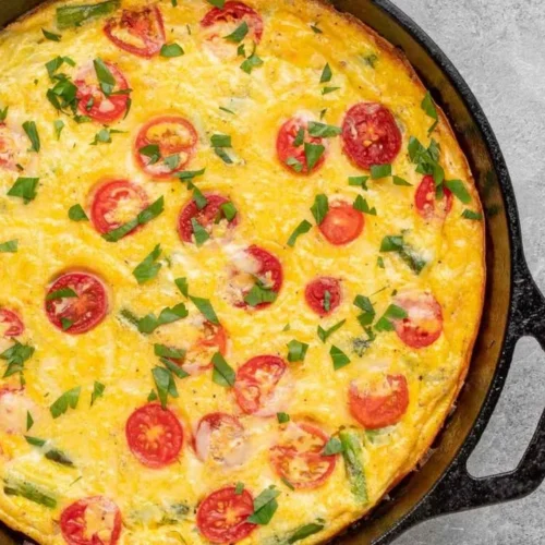 Delicious easy frittata with fresh vegetables and herbs on a plate