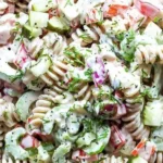Bowl of easy pasta salad with pickles, colorful veggies, and dressing