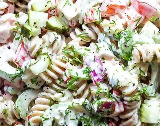 Bowl of easy pasta salad with pickles, colorful veggies, and dressing