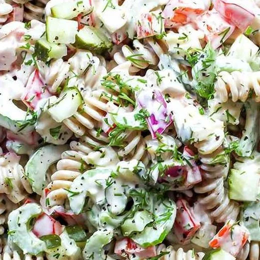 Bowl of easy pasta salad with pickles, colorful veggies, and dressing
