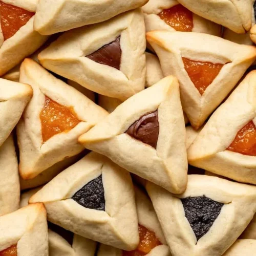 Homemade Hamantaschen cookies filled with fruit preserves and shaped like a triangle