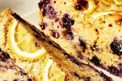 High-protein lemon-blueberry cake topped with fresh blueberries and lemon zest
