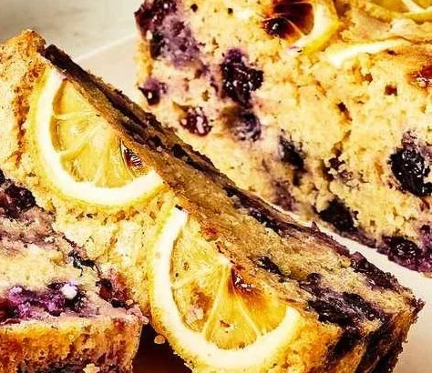 High-protein lemon-blueberry cake topped with fresh blueberries and lemon zest