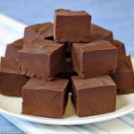 Delicious bowl of ice cream fudge topped with chocolate and nuts