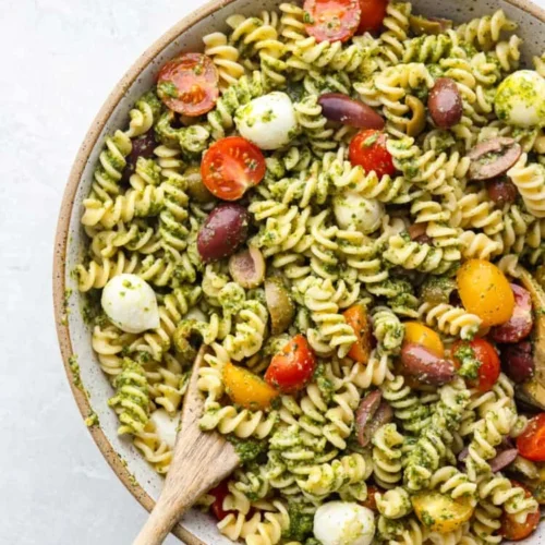 Fresh pesto pasta salad with vegetables and herbs in a bowl