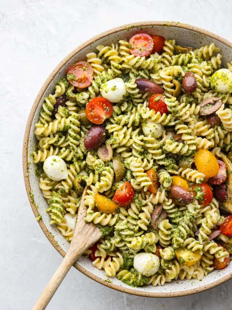 Fresh pesto pasta salad with vegetables and herbs in a bowl