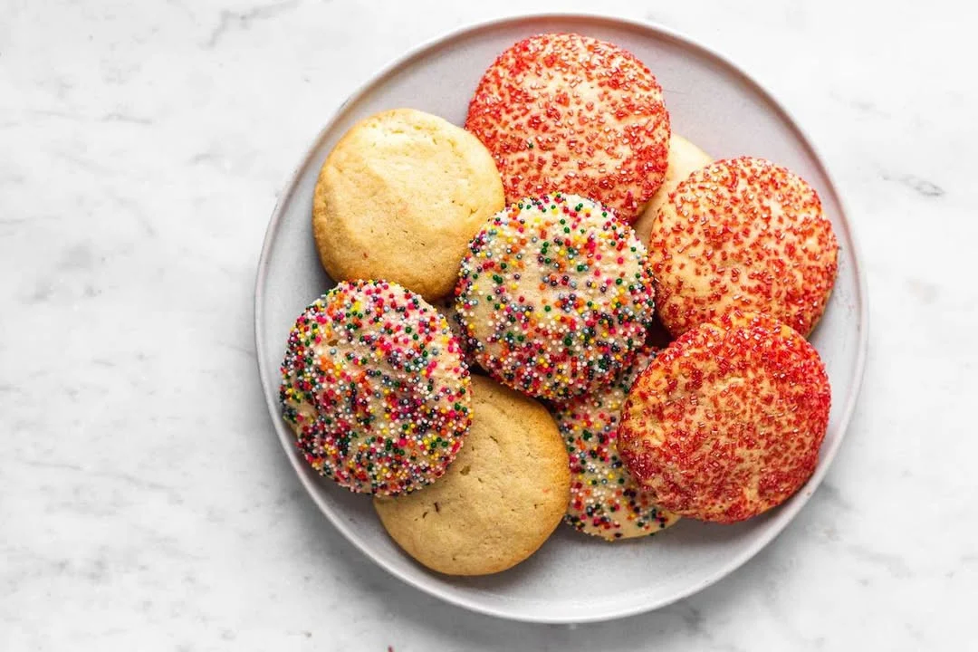 Batch of soft sugar cookies on a plate with festive decorations.