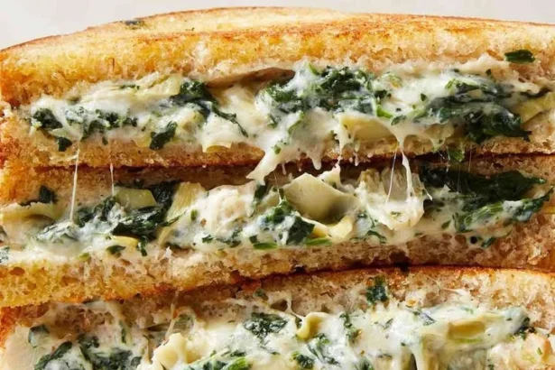 Spinach artichoke dip grilled cheese sandwich with gooey cheese and vegetables