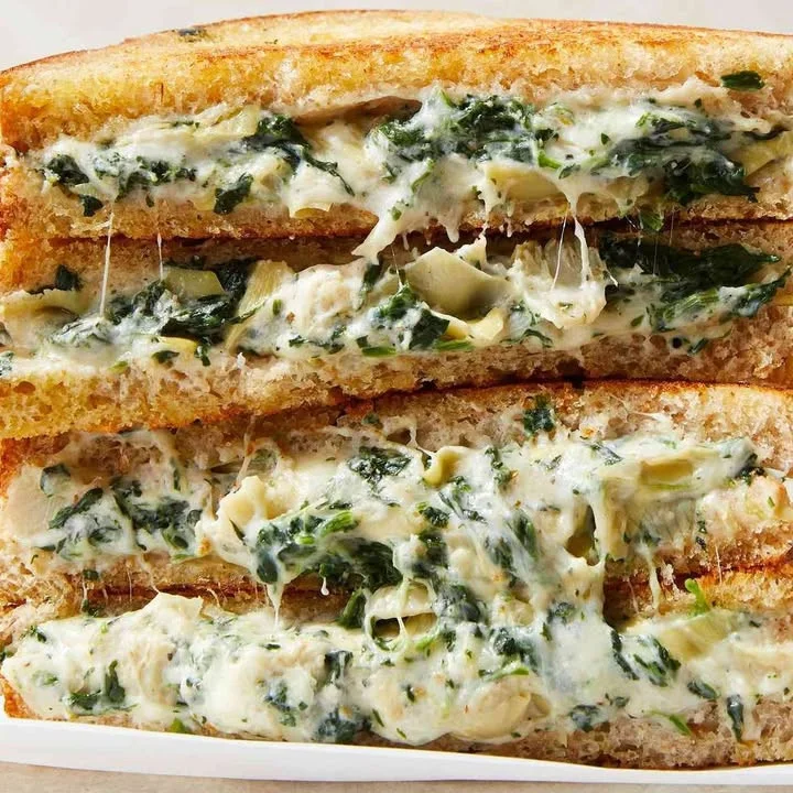 Spinach artichoke dip grilled cheese sandwich with gooey cheese and vegetables