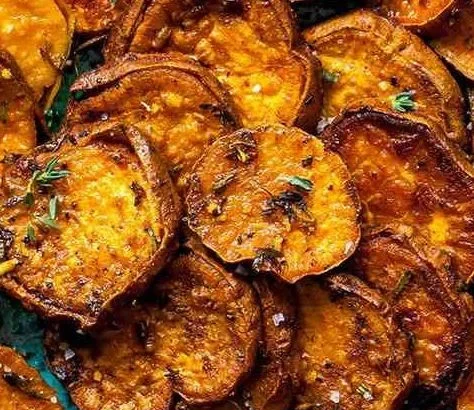 Savory sweet potatoes with earthy herbs and spices, beautifully plated.