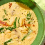 Bowl of delicious Tomato and Bean Soup garnished with fresh herbs.