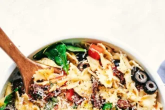 Colorful Tuscan Pasta Salad with tomatoes, olives, and basil in a bowl