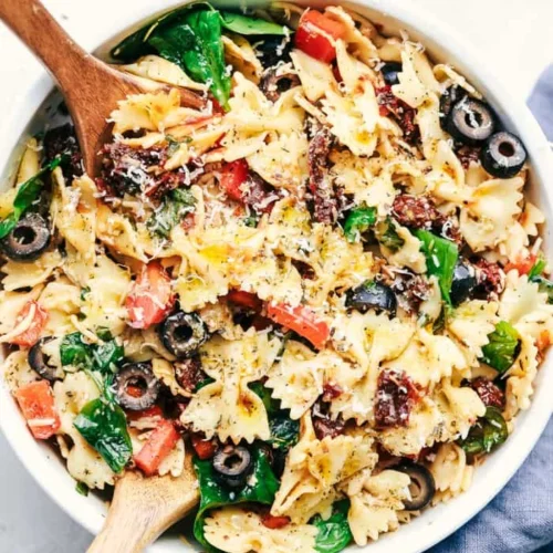 Colorful Tuscan Pasta Salad with tomatoes, olives, and basil in a bowl