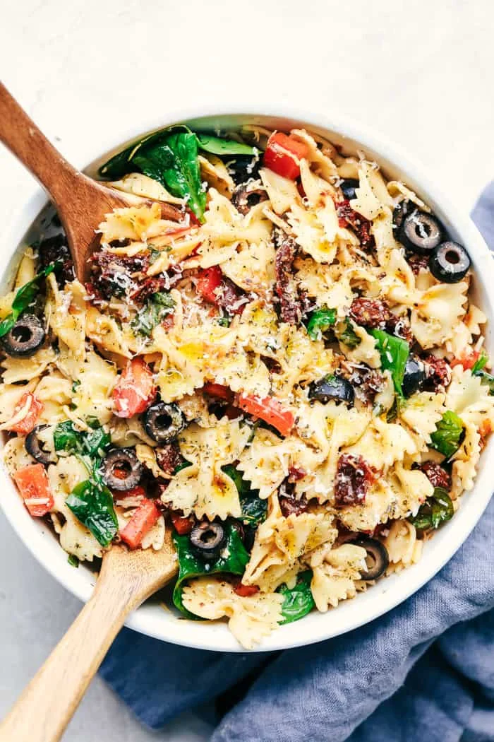 Colorful Tuscan Pasta Salad with tomatoes, olives, and basil in a bowl