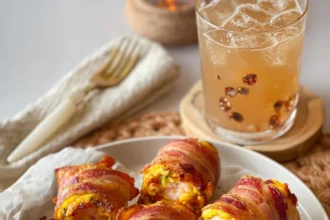 Delicious Bacon-Wrapped Shrimp Rolls topped with melted cheese on a plate.