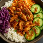 Korean-style BBQ chicken bowls with crunchy cabbage and sesame garnish