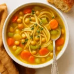 Delicious bowl of 1-Pot Chickpea Noodle Soup garnished with herbs