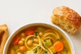 Delicious bowl of 1-Pot Chickpea Noodle Soup garnished with herbs
