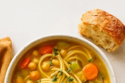Delicious bowl of 1-Pot Chickpea Noodle Soup garnished with herbs
