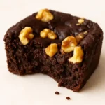 Delicious black bean brownies topped with cacao and nuts on a wooden table.