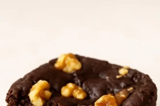 Delicious black bean brownies topped with cacao and nuts on a wooden table.
