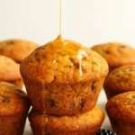 Freshly baked Blackberry Cornmeal Muffins on a wooden platter