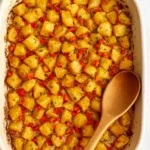 Crispy baked breakfast potatoes served in a bowl, garnished with herbs.