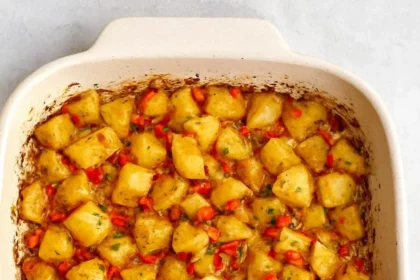 Crispy baked breakfast potatoes served in a bowl, garnished with herbs.