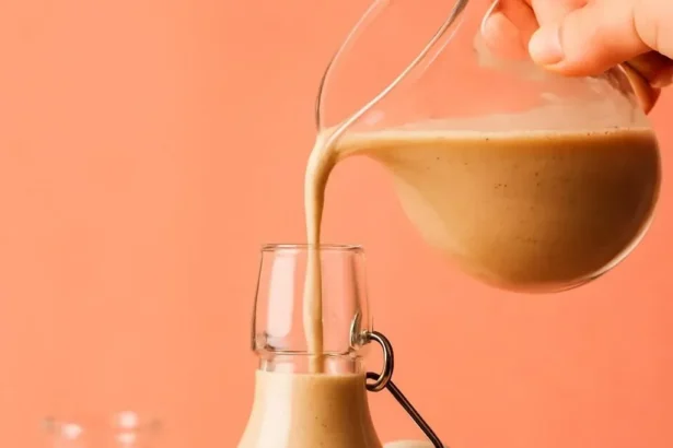 Dairy-free pumpkin spice coffee creamer in a bottle with coffee cup.