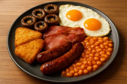 A spread of a traditional English Breakfast featuring eggs, bacon, and beans.