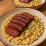 Delicious Garlic Steak served with creamy Parmesan pasta on a plate.