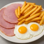 Plate of ham, eggs, and chips served for breakfast or brunch