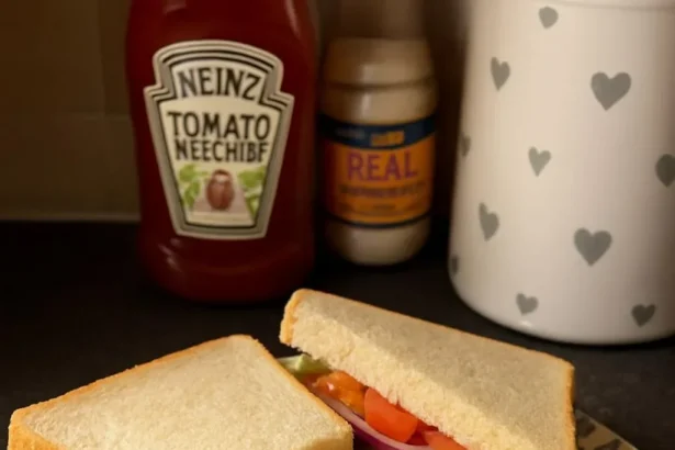 Delicious ham sandwich with a side of salad and chips on a plate
