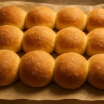 Freshly baked homemade bread rolls on a wooden table