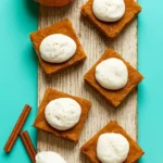 Delicious Pumpkin Pie Bars topped with whipped cream and spices