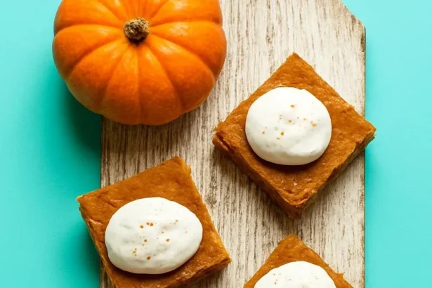 Delicious Pumpkin Pie Bars topped with whipped cream and spices