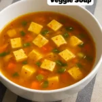 Bowl of turmeric miso soup with fresh ingredients and vibrant colors