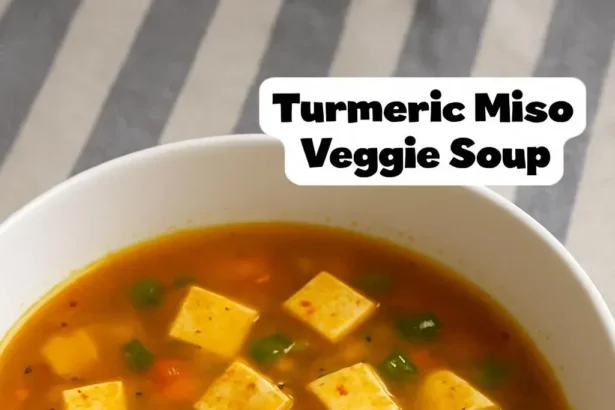 Bowl of turmeric miso soup with fresh ingredients and vibrant colors