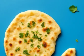 Freshly baked vegan naan served with curry on a wooden board
