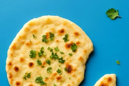 Freshly baked vegan naan served with curry on a wooden board
